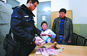 徐成带着儿子将9.5万余元现金交到民警手中。